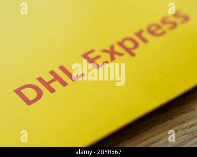 Cartello rosso DHL sopra la confezione della busta gialla Foto Stock