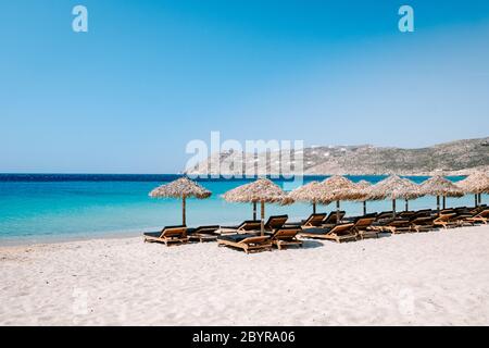 Sedie da spiaggia tropicali con ombrellone sulla spiaggia di Mykonos Grecia Foto Stock