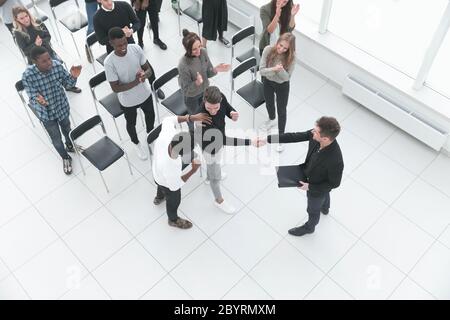 Immagine da sopra della gente di affari seduti intorno a conferenza de Foto Stock