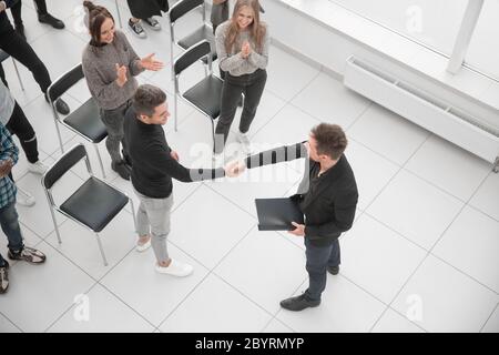 Immagine da sopra della gente di affari seduti intorno a conferenza de Foto Stock