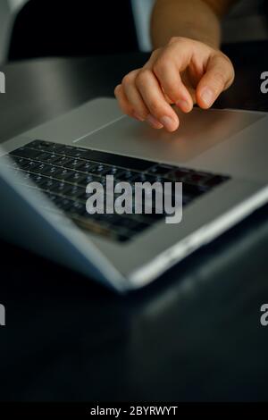 Primo piano della mano maschile caucasica sul touchpad del moderno laptop Foto Stock