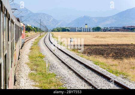Vista di Podgorica (capitale montenegrina) dal treno lungo la ferrovia Bar-Belgrado nei Balcani (Montenegro, Serbia) Foto Stock
