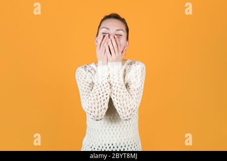 la ragazza risata sinceramente e si sbatte, coprendo il viso con le mani Foto Stock