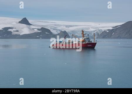 Una nave di ricerca nella baia di Admiralty sull'isola di re George nelle isole del sud di Shetland, Antartide. Foto Stock