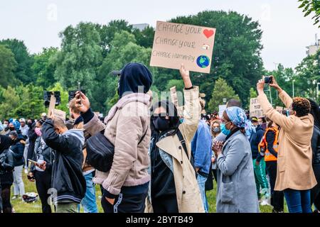 Amsterdam, Paesi Bassi. 10 giugno 2020. Tra la folla, un manifesto femminile che tiene un tavolo dicendo: 'Cambiare il vostro cuore, cambiare la vostra casa, cambiare l'umanità'. Si stima che 11.500 partecipanti si siano riuniti pacificamente nel Parco Nelson Mandela per la seconda manifestazione di Black Lives Matter ad Amsterdam. Questo incontro è stato organizzato dai residenti del Bijlmer, il distretto con la più grande popolazione di Afro-Dutch ad Amsterdam. Per decenni i membri della comunità nera del Bijlmer sono stati vittime di discriminazioni, repressione e razzismo. Credit: Steppeland/Alamy Live News Foto Stock