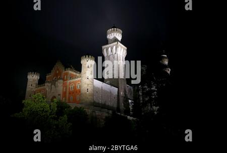 Schwangau, Germania. 10 Giugno 2020. Alla luce di 47 faretti a LED, il Castello di Neuschwanstein è in piedi sotto la pioggia. La conversione al nuovo sistema di illuminazione costa 300,000 euro. I faretti non solo dovrebbero fornire una luce migliore, ma anche essere più insetto-friendly e risparmiare energia elettrica. Credit: Karl-Josef Hildenbrand/dpa/Alamy Live News Foto Stock