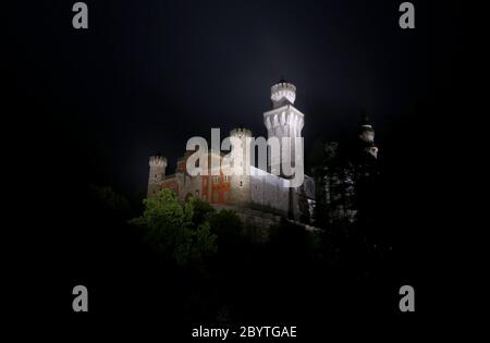 Schwangau, Germania. 10 Giugno 2020. Alla luce di 47 faretti a LED, il Castello di Neuschwanstein è in piedi sotto la pioggia. La conversione al nuovo sistema di illuminazione costa 300,000 euro. I faretti non solo dovrebbero fornire una luce migliore, ma anche essere più insetto-friendly e risparmiare energia elettrica. Credit: Karl-Josef Hildenbrand/dpa/Alamy Live News Foto Stock