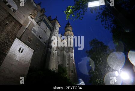 Schwangau, Germania. 10 Giugno 2020. Alla luce di 47 faretti a LED, il Castello di Neuschwanstein è in piedi sotto la pioggia. La conversione al nuovo sistema di illuminazione costa 300,000 euro. I faretti non solo dovrebbero fornire una luce migliore, ma anche essere più insetto-friendly e risparmiare energia elettrica. Credit: Karl-Josef Hildenbrand/dpa/Alamy Live News Foto Stock