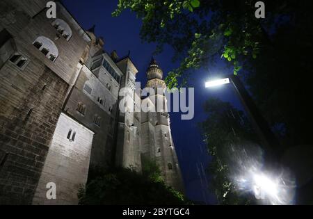 Schwangau, Germania. 10 Giugno 2020. Alla luce di 47 faretti a LED, il Castello di Neuschwanstein è in piedi sotto la pioggia. La conversione al nuovo sistema di illuminazione costa 300,000 euro. I faretti non solo dovrebbero fornire una luce migliore, ma anche essere più insetto-friendly e risparmiare energia elettrica. Credit: Karl-Josef Hildenbrand/dpa/Alamy Live News Foto Stock