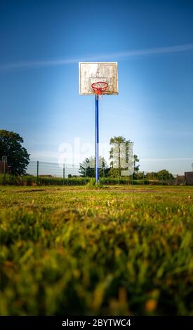 canestro in campo in giornata di sole con cielo blu Foto Stock