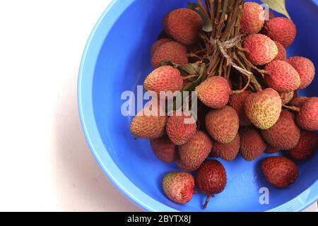 Ritchi rossi freschi, lichee, lychee, o litchi in una ciotola colorata, primo piano di fotografia Foto Stock