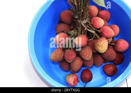 Ritchi rossi freschi, lichee, lychee, o litchi in una ciotola colorata, primo piano di fotografia Foto Stock