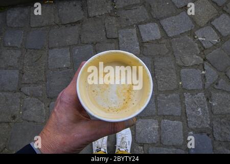 Caffè del mattino take away. L uomo è in possesso di bicchiere di carta con caffè sulla strada. Foto Stock