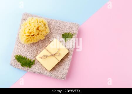 Sapone fatto a mano con olio di oliva e argan, spugna naturale di mare, zero rifiuti riutilizzabili articoli da bagno su sfondo blu rosa spazio copia Foto Stock