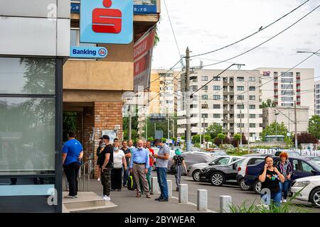 10 giugno 2020 - Bucarest, Romania. Persone che aspettano in fila e mantenere una distanza sociale per arrivare in banca BCR Foto Stock