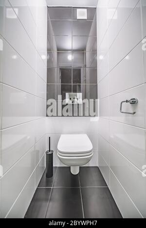 WC in bianco incorporato in bagno moderno con supporto carta e spazzola wc Foto Stock