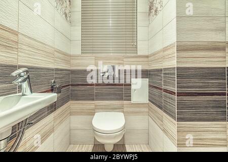 WC in bianco incorporato in bagno moderno con supporto carta e spazzola wc Foto Stock