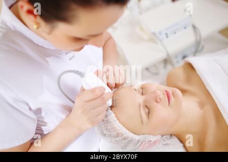 Faccia ad ultrasuoni di pulizia presso il centro di bellezza e benessere Foto Stock