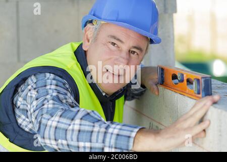 uomo professionista senior che usa la livella a bolla Foto Stock