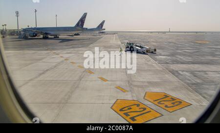 Equipaggio di terra sul asfalto presso un aeroporto internazionale di Doha quasi desertato durante il blocco causato dal virus COVID-19. In tutto il mondo, il settore del traffico aereo è fortemente influenzato dal massiccio calo del traffico. Foto Stock