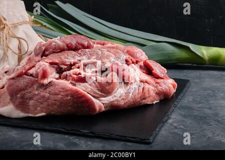 Collo di maiale crudo perfetto con spezie, primo piano su un tagliere di legno. Imballaggio ecologico, foto per negozi di alimentari. Foto Stock