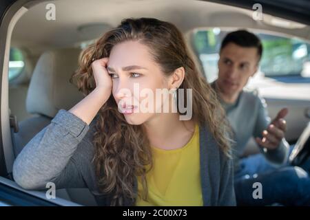 Donna penosa triste e uomo malinteso in auto Foto Stock