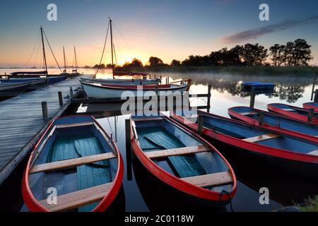 barche e yacht sul lago all'alba Foto Stock