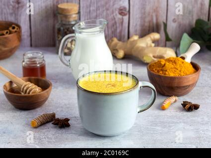 Tazza con latte curcuma dorato e ingredienti Foto Stock