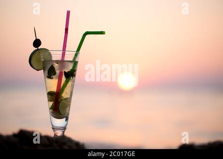 Cocktail Mojito sulla spiaggia al tramonto Foto Stock