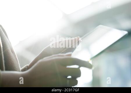 Donna che utilizza un tablet PC contro la luce diretta del sole Foto Stock