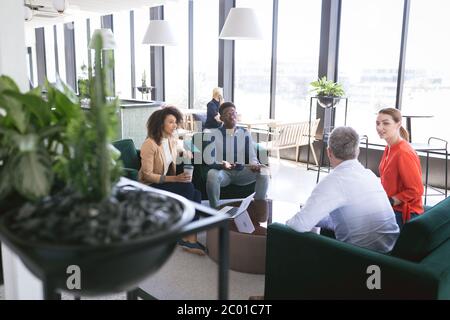 Multireghe uomini d'affari che parlano in un'area di lavoro Foto Stock