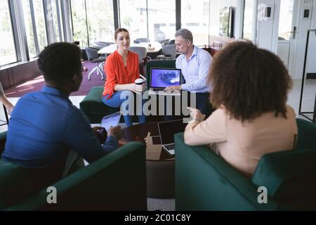 Multireghe uomini d'affari che parlano in un'area di lavoro Foto Stock