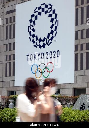 Tokyo, Giappone. 11 Giugno 2020. I pedoni passano prima dell'emblema dei Giochi Olimpici di Tokyo presso l'edificio del governo metropolitano di Tokyo giovedì 11 giugno 2020. Il Comitato organizzatore delle Olimpiadi di Tokyo e il Comitato Olimpico Internazionale (CIO) hanno convenuto che il prossimo anno avrebbero semplificato i giochi olimpici per garantire la sicurezza del nuovo coronavirus. Credit: Yoshio Tsunoda/AFLO/Alamy Live News Foto Stock