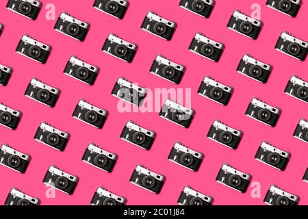 Fotocamera retro isolata su sfondo rosa brillante motivo creativo. Concetto di pop art. Disposizione piatta in stile minimal Foto Stock