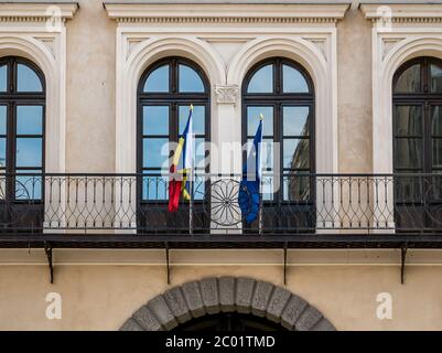 Dettaglio architettonico di un edificio istituzionale a Bucarest. Rumeno un'Unione europea bandiere su un balcone in Romania. Foto Stock
