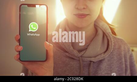 KIEV, UCRAINA-GENNAIO, 2020: WhatsApp sullo schermo del telefono cellulare. Young Girl mostra lo schermo dello smartphone con Whatsapp mentre si guarda la fotocamera. Attenzione allo smartphone. Foto Stock