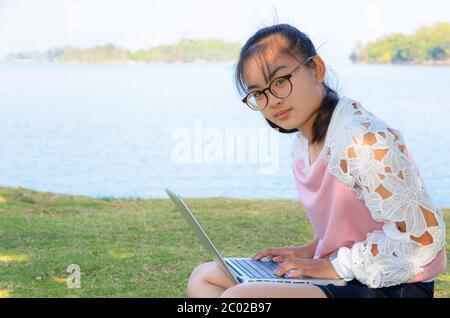 Ragazza giovane con il laptop sull'erba Foto Stock