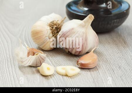 Vista ravvicinata dell'aglio crudo pelato e delle lampadine non pelate su sfondo grigio di legno. Alimenti che aumentano il sistema immunitario. Profondità di campo bassa. Foto Stock