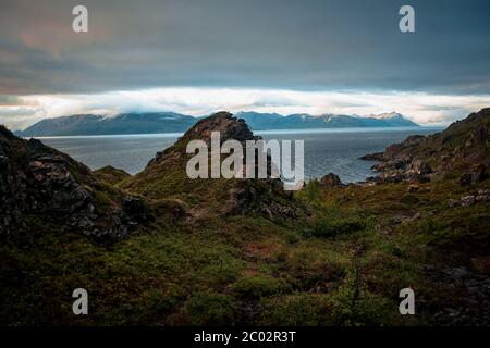 Splendida vista panoramica della Norvegia montagna paesaggio coperto di nuvole durante un vivace tramonto estivo. Preso in cima Lyngen, Norvegia Foto Stock