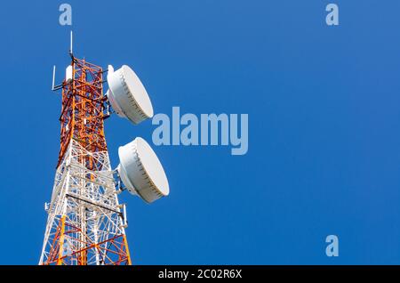 Torre di telecomunicazioni sul cielo blu sullo sfondo Foto Stock