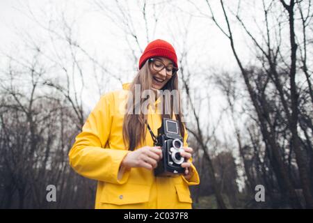 Donna fotografo in impermeabile giallo con fotocamera vintage Foto Stock