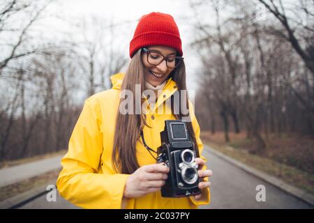 Donna fotografo in impermeabile giallo con fotocamera vintage Foto Stock