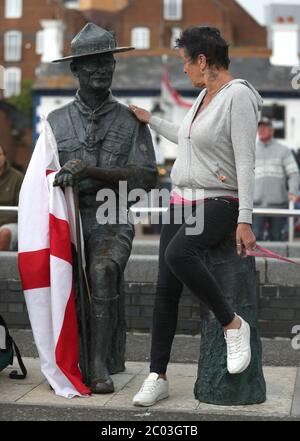 Gli abitanti del luogo mostrano il loro sostegno per una statua di Robert Baden-Powell su Poole Quay a Dorset, prima della sua prevista rimozione per 'sicuro deposito' a seguito di preoccupazioni circa le sue azioni mentre si trova nelle 'simpatie militari e naziste'. L'azione segue una serie di proteste sulla materia Black Lives in tutto il Regno Unito, scatenate dalla morte di George Floyd, ucciso il 25 maggio mentre era in custodia di polizia nella città americana di Minneapolis. Foto Stock