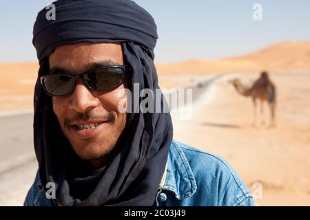 Il tribesman berbero con il suo cammello nel deserto del Sahara, in Nord Africa. Foto Stock