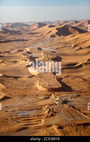 La costruzione di una nuova pista per assistere alla creazione di un grande impianto di petrolio e gas nel deserto del Sahara. Foto Stock