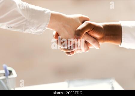 Stretta di mano tra l'uomo d'affari africano e caucasico. Foto Stock