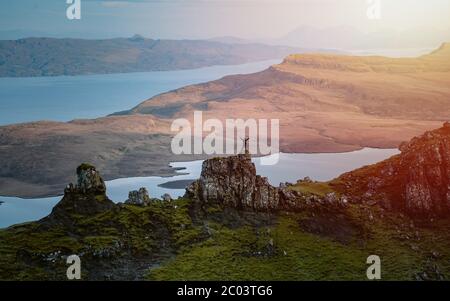 Vista posteriore del turista con zaino che sale in collina esplorando l'ambiente naturale. Una delle meraviglie più fotografate al mondo. Scozia Foto Stock