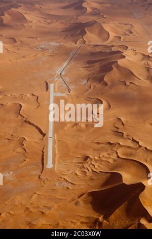 La costruzione di una nuova pista per assistere alla creazione di un grande impianto di petrolio e gas nel deserto del Sahara. Foto Stock