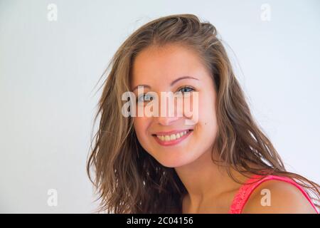 Giovane donna sorridente e guardando la telecamera. Foto Stock