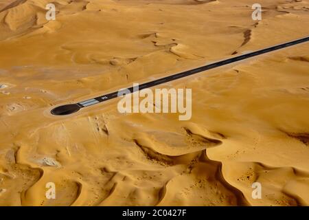 La costruzione di una nuova pista per assistere alla creazione di un grande impianto di petrolio e gas nel deserto del Sahara. Foto Stock